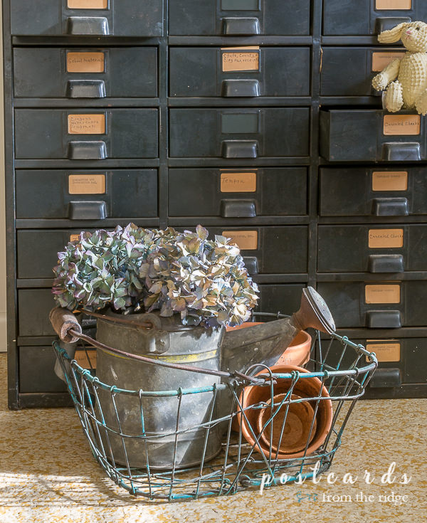 Garden-inspired decor. Love all of these easy ways to add some garden-inspired decor to your home! #homedecor #gardendecor #cottagedecor #vintagedecor vintage wire basket with dried hydrangeas and terra cotta pots